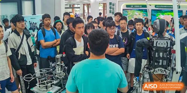 A large group of male students looking intently at a presentation or demonstration being given by a peer or teacher at Suzhou Foreign Language School.