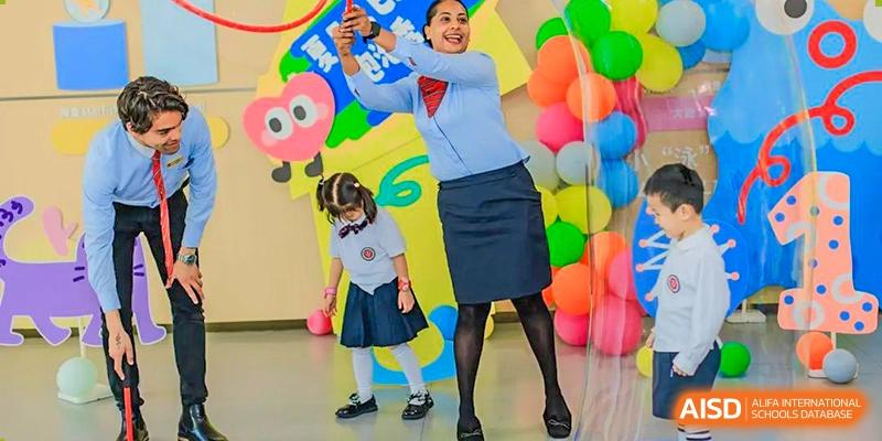 Teacher and young student participating in a brightly decorated, fun activity indoors at Suzhou Foreign Language School.
