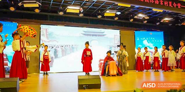 Students performing on a stage in traditional Chinese opera or historical costumes at Suzhou Foreign Language School.