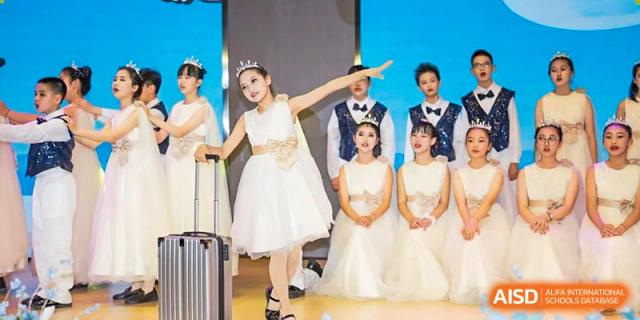 A group of students dressed in formal white attire, possibly performing a theatrical or musical number on stage at Suzhou Foreign Language School.