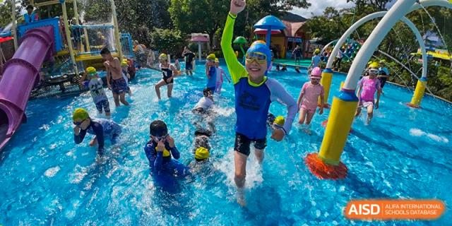Young students enjoying a fun swimming activity or lesson in a pool with instructors at Suzhou Foreign Language School.