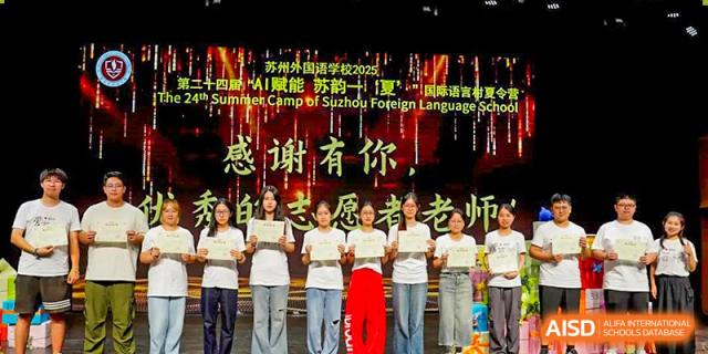 A group of students and teachers standing on stage in white shirts, celebrating an achievement or school event at Suzhou Foreign Language School.