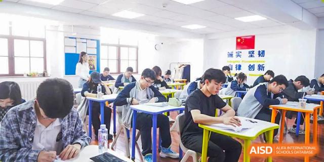Students studying, taking notes, and working independently in a well-lit standard classroom setting at Tianjin Farragut School.