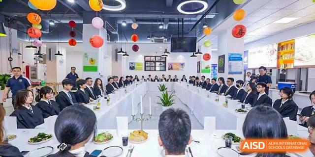 Students and adults seated around a large table decorated with balloons, attending a formal dinner or school event at Tianjin Farragut School.