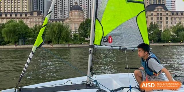 A close-up of a sailboat's rigging and sail on the water during a sailing lesson or activity near Tianjin Farragut School.