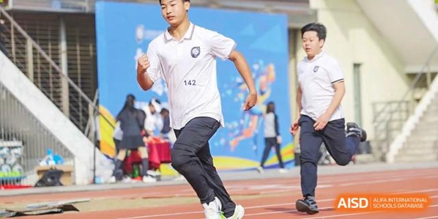 A close-up of a student running in a track and field race or sports day event at Tianjin Farragut School.