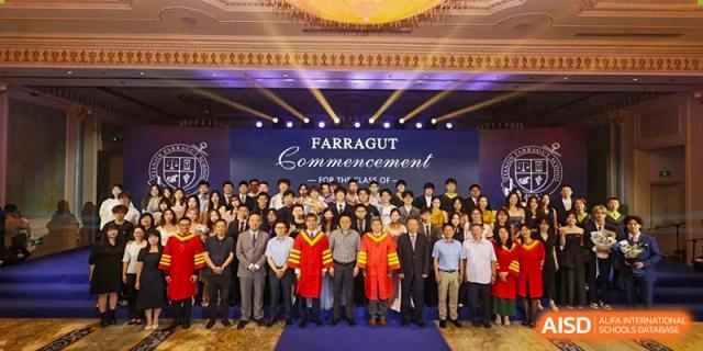 A large group photo of graduates, faculty, and staff in robes and formal attire at the Farragut Commencement ceremony at Tianjin Farragut School.
