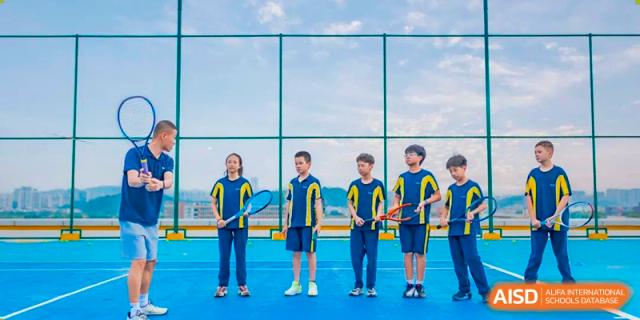 Five students in matching sports uniforms are lined up on a blue sports court at Ardingly College Zhongshan (ACZS), looking ready to compete, emphasizing athletic participation and school spirit.