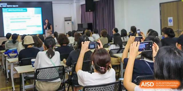 Parents and teachers attend an informational presentation in a large lecture hall at Korea International School in Shenzhen.