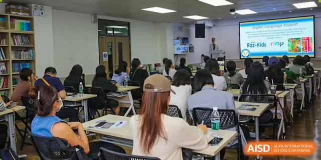 An educator leads a workshop for a group of attentive students in a modern, bright classroom at Korea International School in Shenzhen.