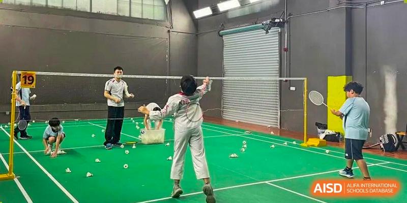 A student practices badminton drills on a court scattered with shuttlecocks during gym class at Korea International School in Shenzhen.