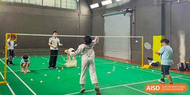 A student practices badminton drills on a court scattered with shuttlecocks during gym class at Korea International School in Shenzhen.