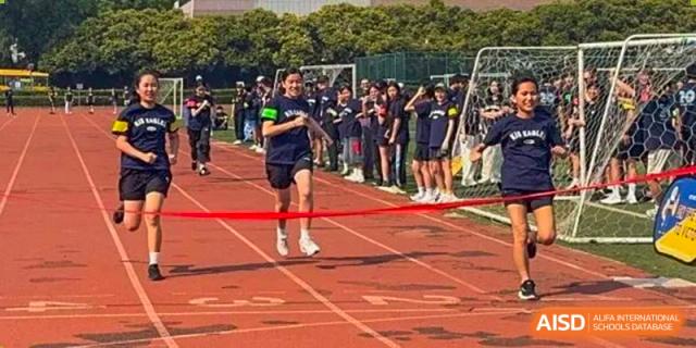 A student athlete sprints across the finish line during a track and field competition on the school grounds at Korea International School in Shenzhen.