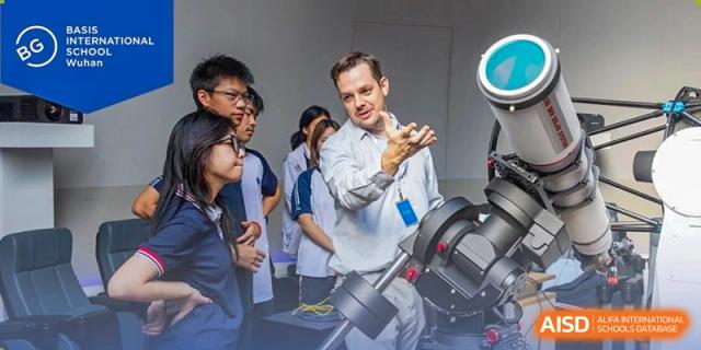 A teacher explaining astronomical equipment to a group of interested students in a science lab at BASIS International School Wuhan.