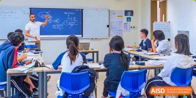Students seated in a bright classroom focusing on a lesson written on the whiteboard at BASIS International School Wuhan.
