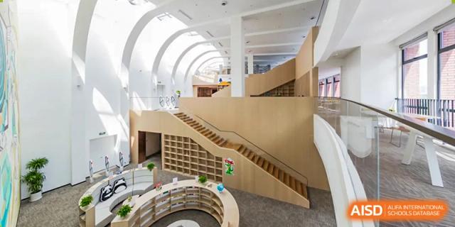 A wide view of a modern, multi-level school library with light wood finishings and open spaces at BASIS International School Wuhan.