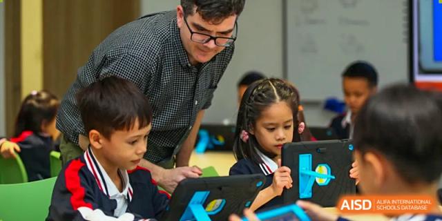 Young students working on tablets with the guidance of a teacher during a classroom activity at BASIS International School Wuhan.