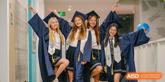 A group of graduating students posing together in their navy blue academic caps and gowns at BASIS International School Wuhan.