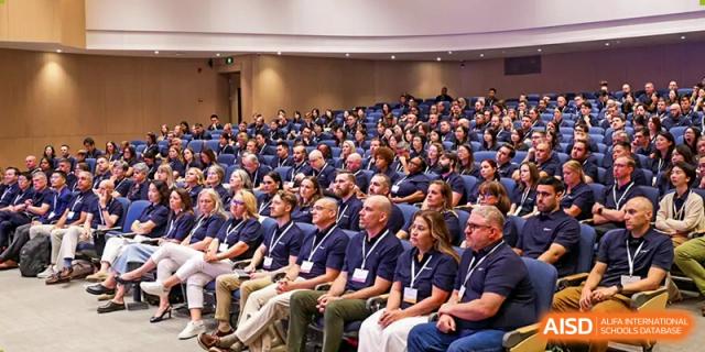 Large group of faculty and staff seated in a modern auditorium for a professional presentation at BASIS International School Wuhan.