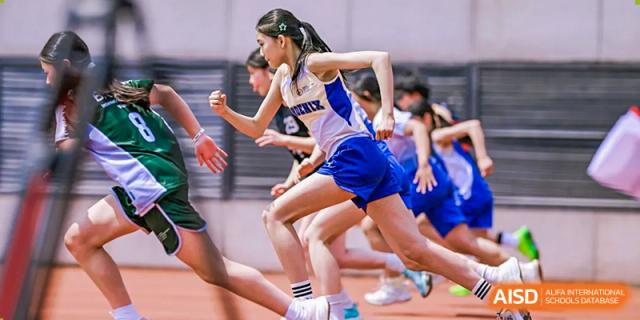 Students in athletic uniforms captured in motion during a competitive track and field race at BASIS International School Wuhan.