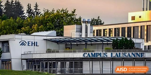 A modern school building facade with the word "CAMPUS" visible, surrounded by greenery under an overcast sky at Hangzhou Entel Foreign Language School.