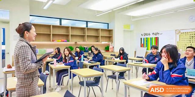 A wide shot of a bright, modern classroom shows several students quietly working at individual desks at BASIS International School Park Lane Harbour.
