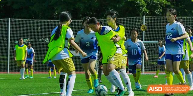 A close-up of girls is playing soccer on the field, actively competing for control of the ball at BASIS International School Park Lane Harbour.