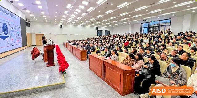 A wide-angle view of an event with a large number of people seated in rows within a brightly lit hall at Nanjing Foreign Language School.
