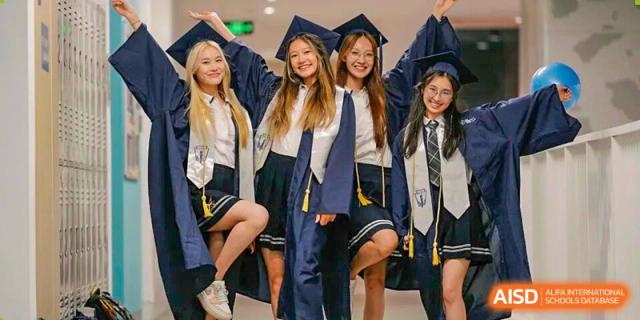 Four female graduates in navy blue caps and gowns smile and pose together during a graduation ceremony at BASIS International School Shenzhen.