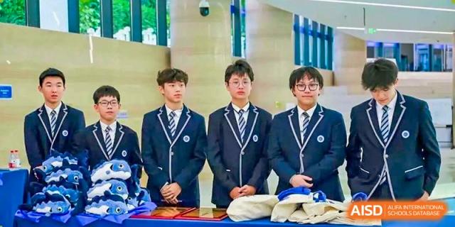 Three male students in formal navy blue school blazers stand together during an official campus event at BASIS International School Shenzhen.