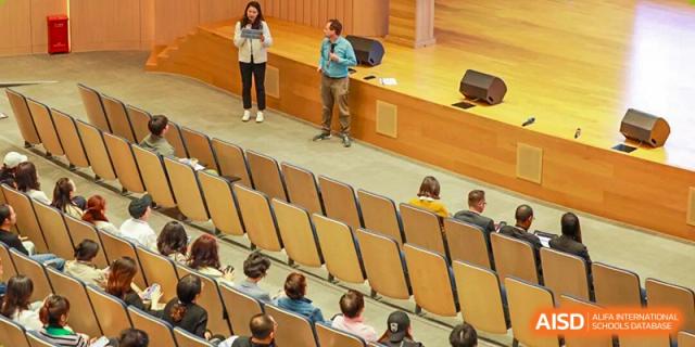 An audience sits in a tiered auditorium during a presentation or school event at BASIS International School Shenzhen.