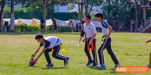 Students participate in a flag football game on a grassy field during an outdoor sports activity at BASIS International School Shenzhen.