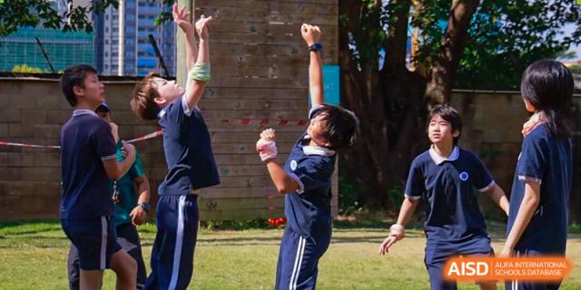 Students reach upward during an outdoor team-building activity or rock climbing session at BASIS International School Shenzhen.