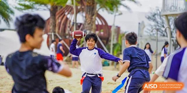 A student smiles while preparing to throw a football during a physical education class at BASIS International School Shenzhen.