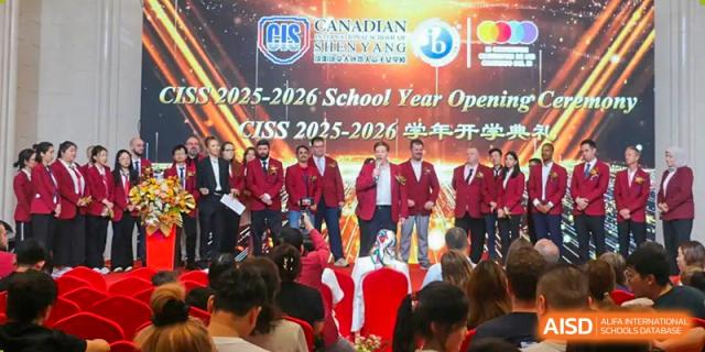 Staff in red blazers stand on stage during the 2025-2026 School Year Opening ceremony held at the Canadian International School of Shenyang.