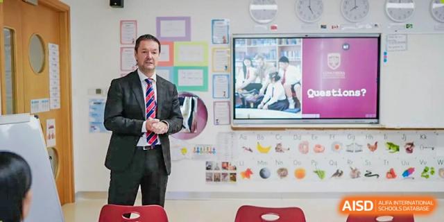 An adult presenting information on a screen in a colorful classroom environment, utilizing technology for education at Concordia International School Ningbo.
