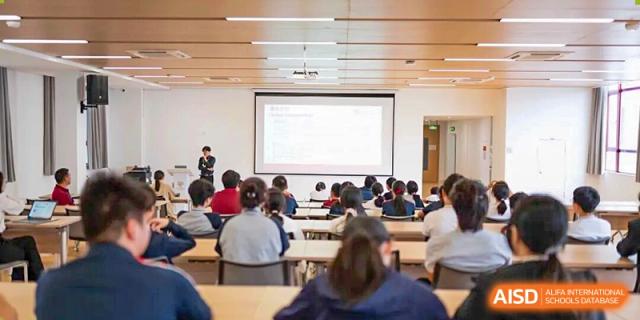 A classroom filled with students sitting at desks, facing a projection screen during a large group lecture or presentation at Concordia International School Ningbo.