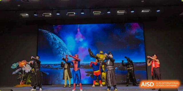 A stage performance featuring costumed characters like Spider-Man and a robot, suggesting a dramatic or theatrical event at Concordia International School Ningbo.