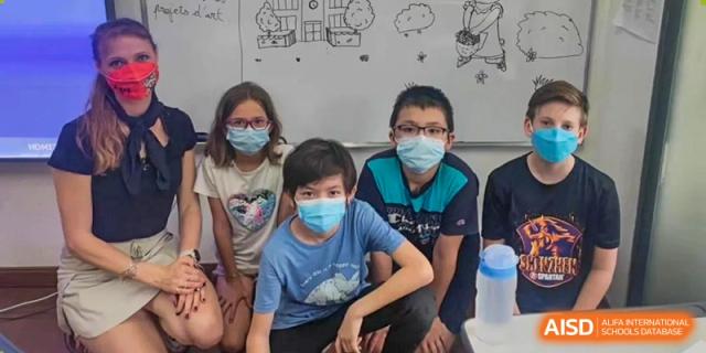 Three young students wearing face masks pose together in a classroom at École Française Internationale de Shenzhen(EFIS).