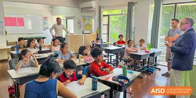 Students sitting at their desks while a teacher stands in the background of a bright classroom at École Française Internationale de Shenzhen(EFIS).
