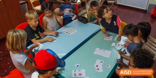 Close-up of students working with educational flashcards on a light blue table during a lesson at École Française Internationale de Shenzhen(EFIS).