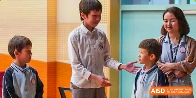 A student in a white button-down shirt talks to a classmate in a bright hallway at École Française Internationale de Shenzhen(EFIS).