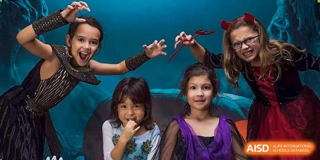 Three young students smile and pose in their festive costumes during a celebration at École Française Internationale de Shenzhen(EFIS).