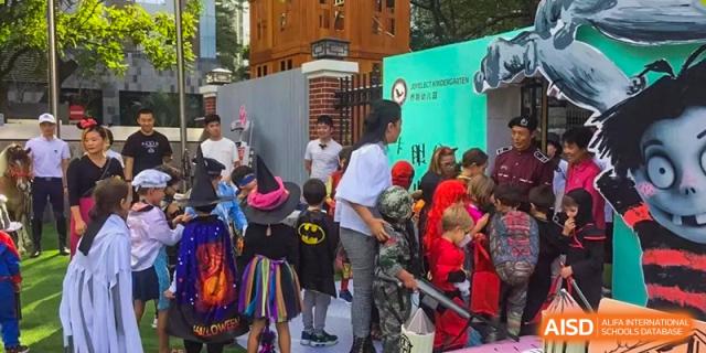 Students in various costumes, including a witch and Batman, gathered outside for a school event at École Française Internationale de Shenzhen(EFIS).