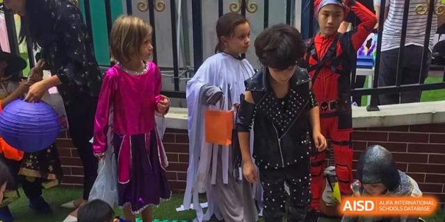 A group of students in various costumes walk together during an outdoor festival at École Française Internationale de Shenzhen (EFIS).