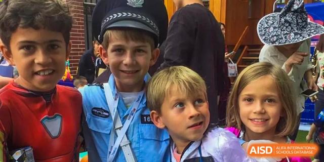 Two boys dressed in police and pilot uniforms pose together during a costume day at École Française Internationale de Shenzhen (EFIS).