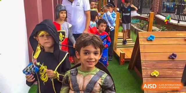 A student wearing a Teenage Mutant Ninja Turtle costume smiles at an outdoor party at École Française Internationale de Shenzhen(EFIS).