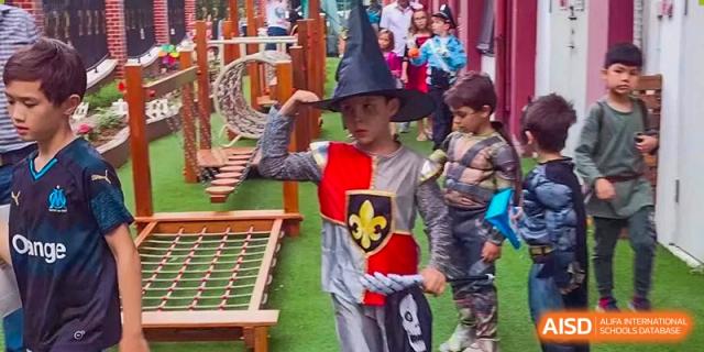 A boy in a medieval knight costume and witch hat explores the playground at École Française Internationale de Shenzhen(EFIS).