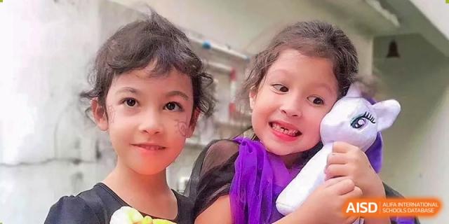 Two young students in costumes smile together for a close-up portrait at École Française Internationale de Shenzhen(EFIS).