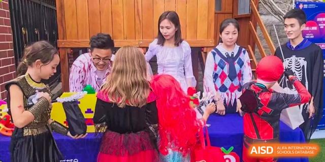 Students dressed in colorful costumes and wigs participate in a festive activity at a table at École Française Internationale de Shenzhen(EFIS).